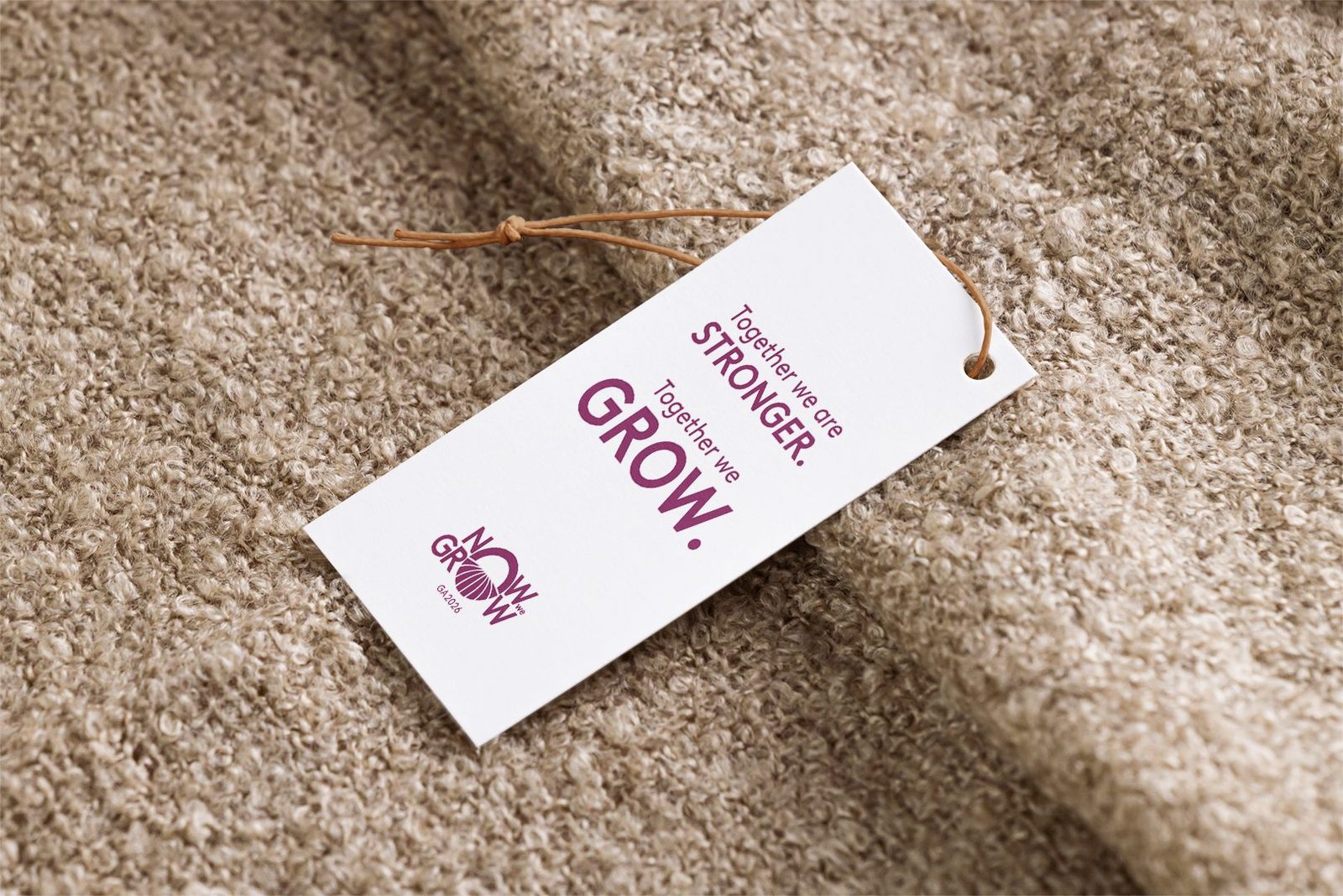 Now We Grow, Budapeste 2026: verso da tag com a frase “Together we are stronger. Together we grow.”