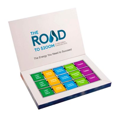The Road, Lago di Garda 2023: caixa de brinde aberta com itens coloridos e a frase “The Energy You Need to Succeed”