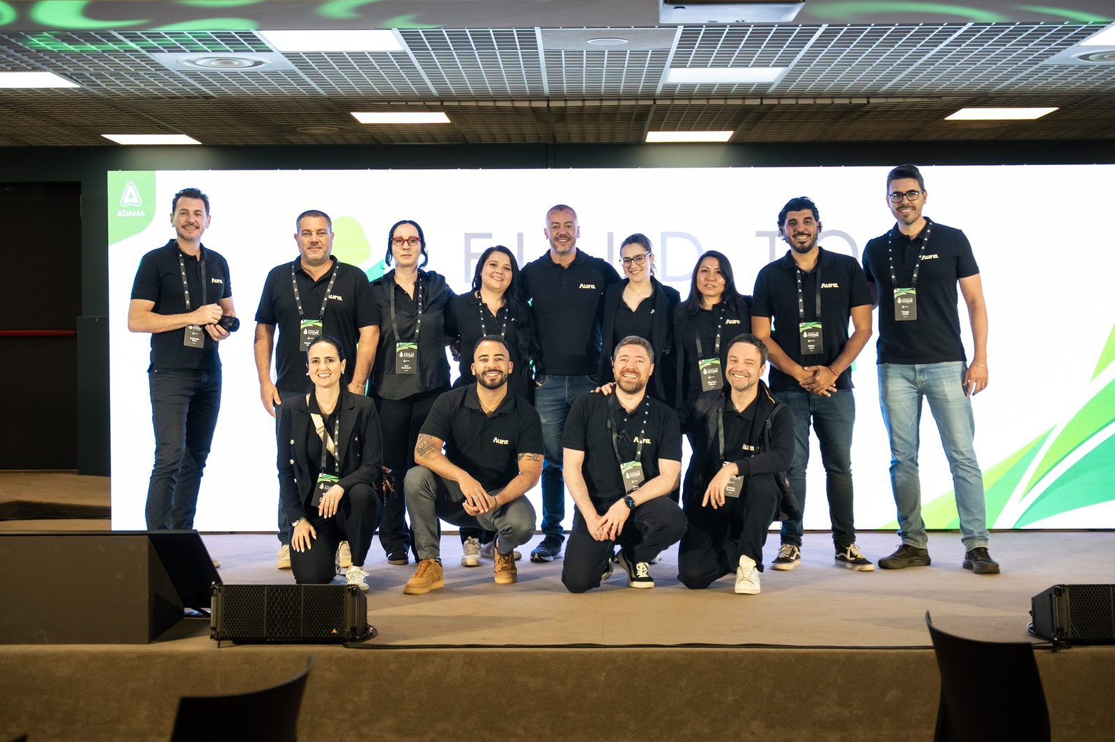 Field to Future, Milão 2026: equipe posando no palco diante da tela do evento