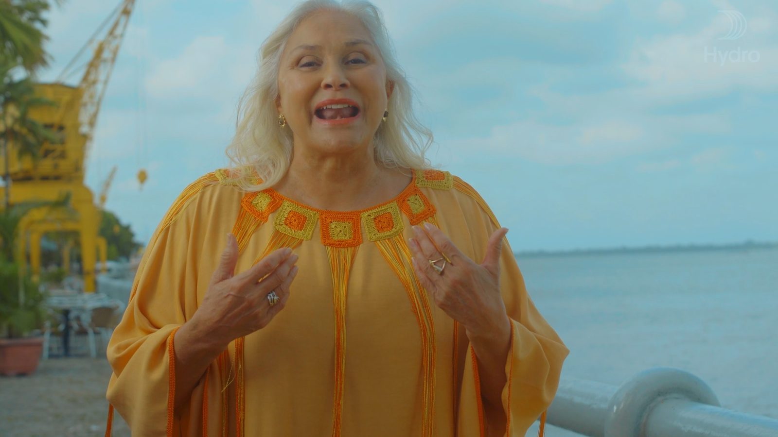 Fafá de Belém falando à câmera, à beira do rio