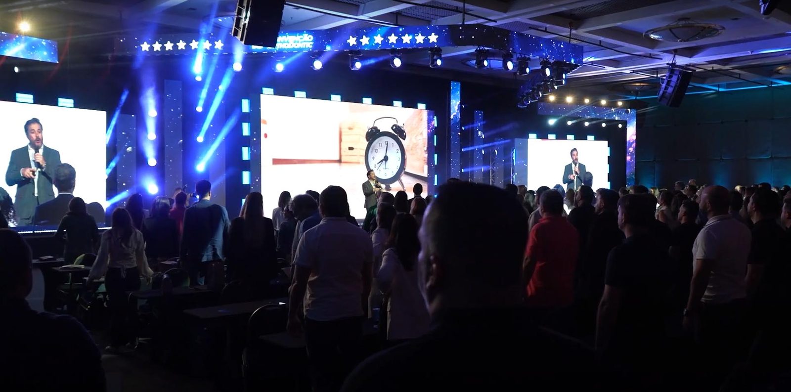 Palestrante no palco, com telão ao fundo