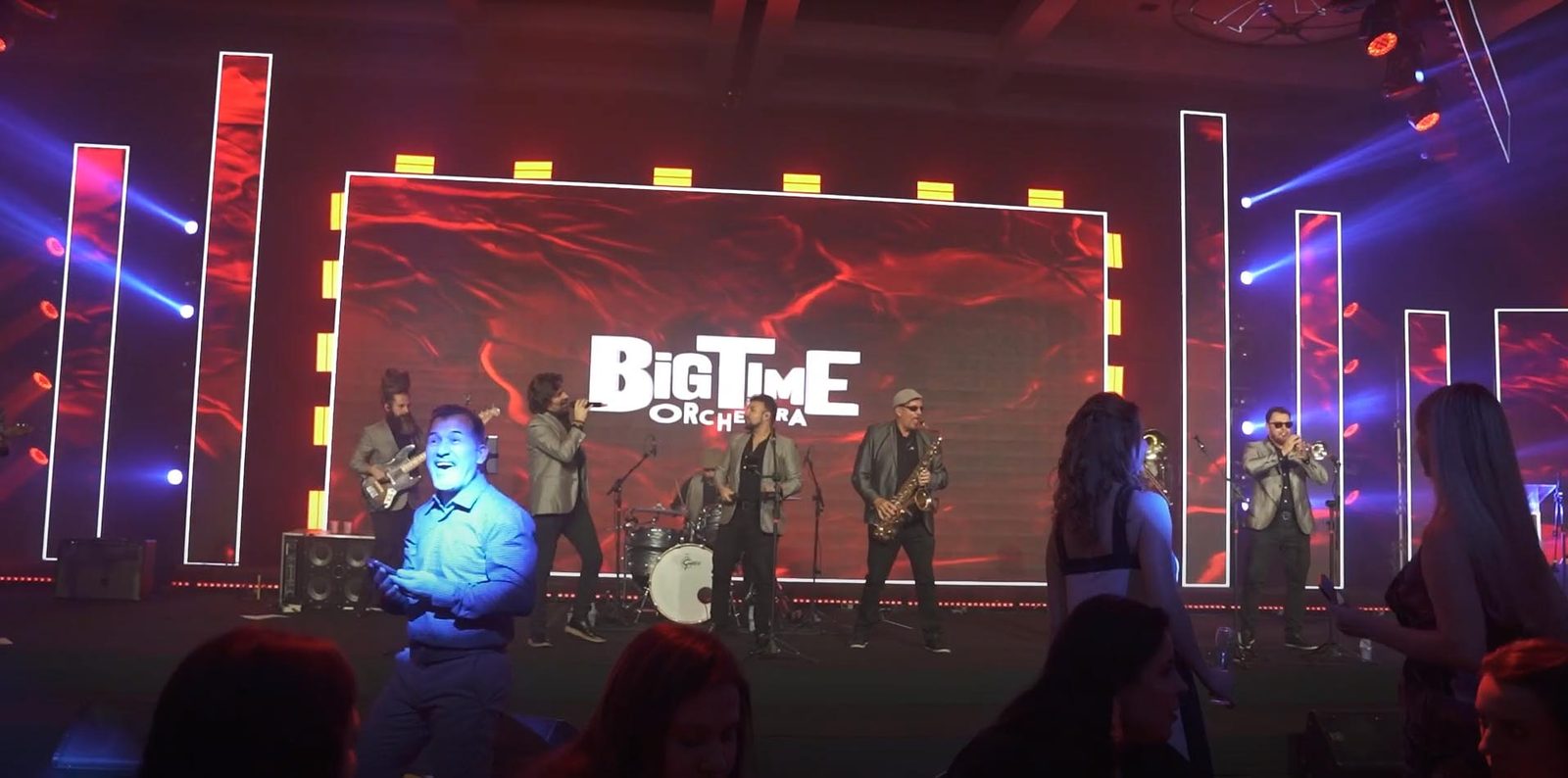 Palco com banda e telão vermelho da convenção