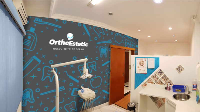 Consultório com parede azul estampada e o logotipo